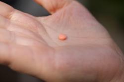 A woman holds an aspirin pill in the Brooklyn borough of New York.