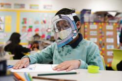 A student wears a mask and face shield in a 4th grade class amid the COVID-19 pandemic at Washington Elementary School.