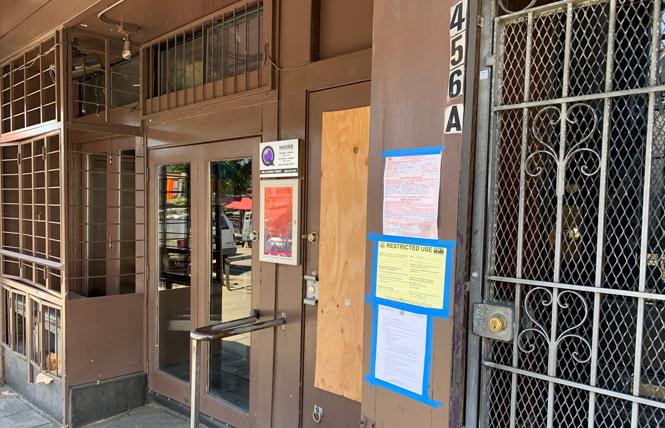 A photo taken last week shows warning signs outside 456 A Castro Street, which was affected by the November 16 fire. Photo: Sari Staver