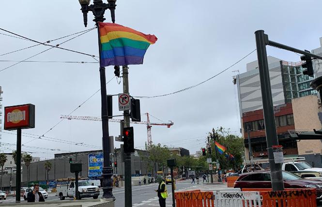 Pride flags were being installed along San Francisco's Market Street Tuesday morning, a day later than usual. Photo: Ernesto Sopprani