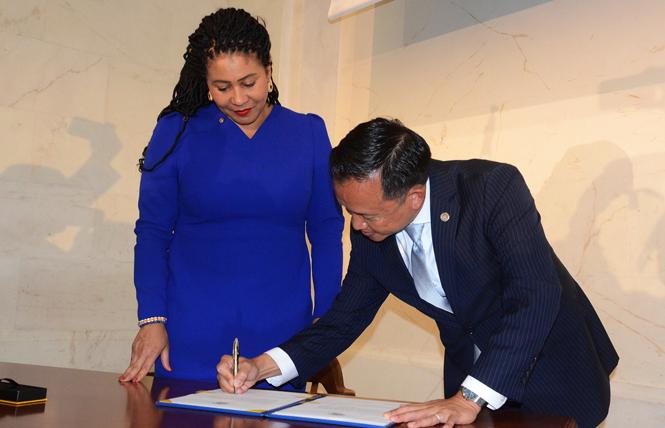 New San Francisco City Attorney David Chiu, right, signed the document to make his position official following being sworn in by Mayor London Breed. Photo: Rick Gerharter