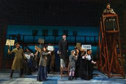 Emma Goldman ( Nicole Paloma Sarro, on podium) addresses strikers and Younger Brother (Jonathan Acorn, on chair) in Wheelock Family Theatre revival of "Ragtime." (Photo: Nile Scott Studios)