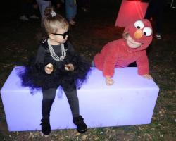 Two-year-old South Enders Nora Pontin and Lorenzo Pallotta portray Audrey Hepburn and Elmo for Halloween as they explore in the glow-in-the-dark play area at the second annual Fall-o-Ween children's festival hosted on October 21 by the Boston Parks and Recreation Department with support from H.P. Hood LLC. The fall celebration on the Boston Common Parade Ground featured games, inflatables, and free, fun activities for kids of all ages.